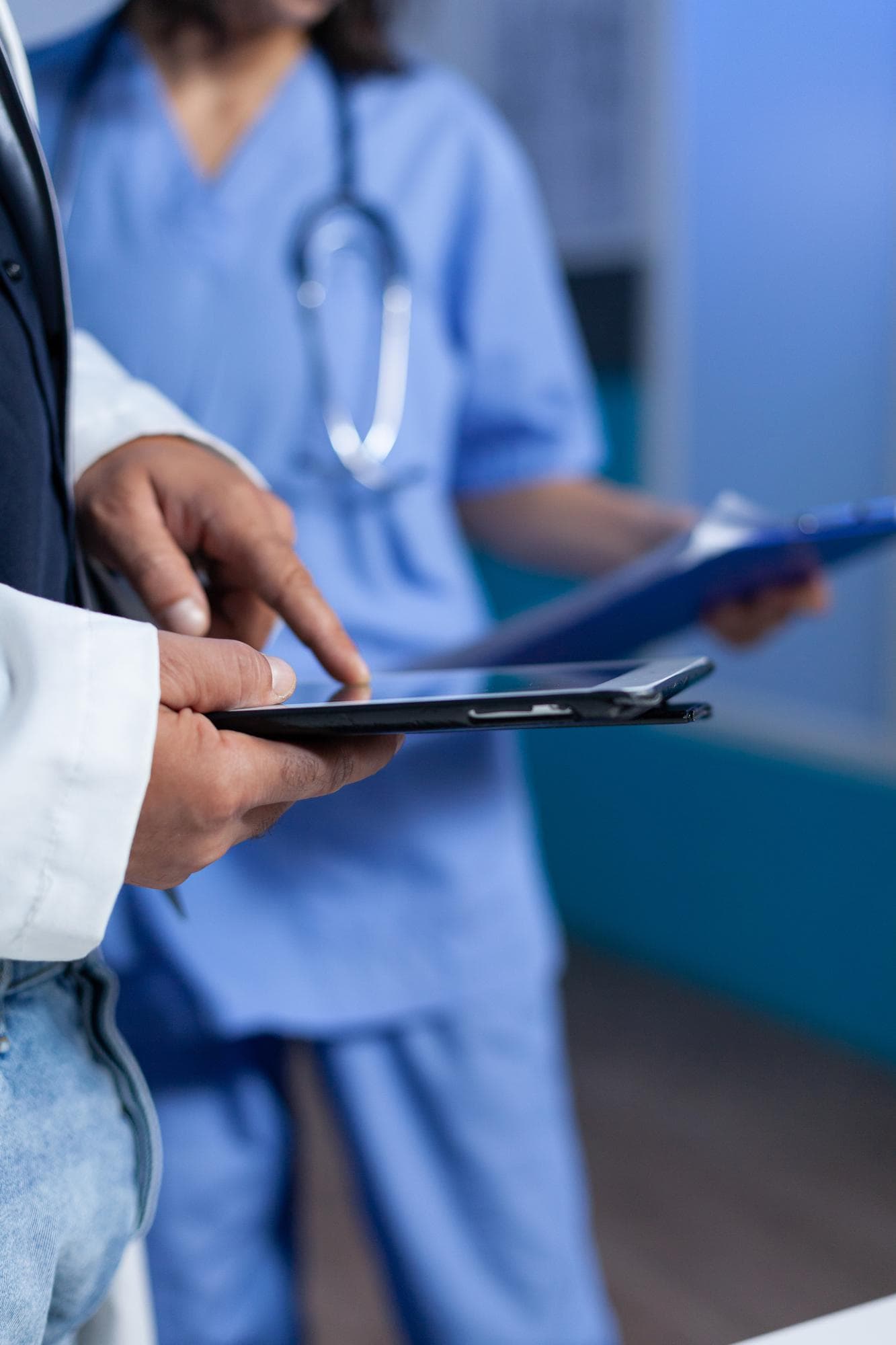 Médico usando una tablet junto a una enfermera